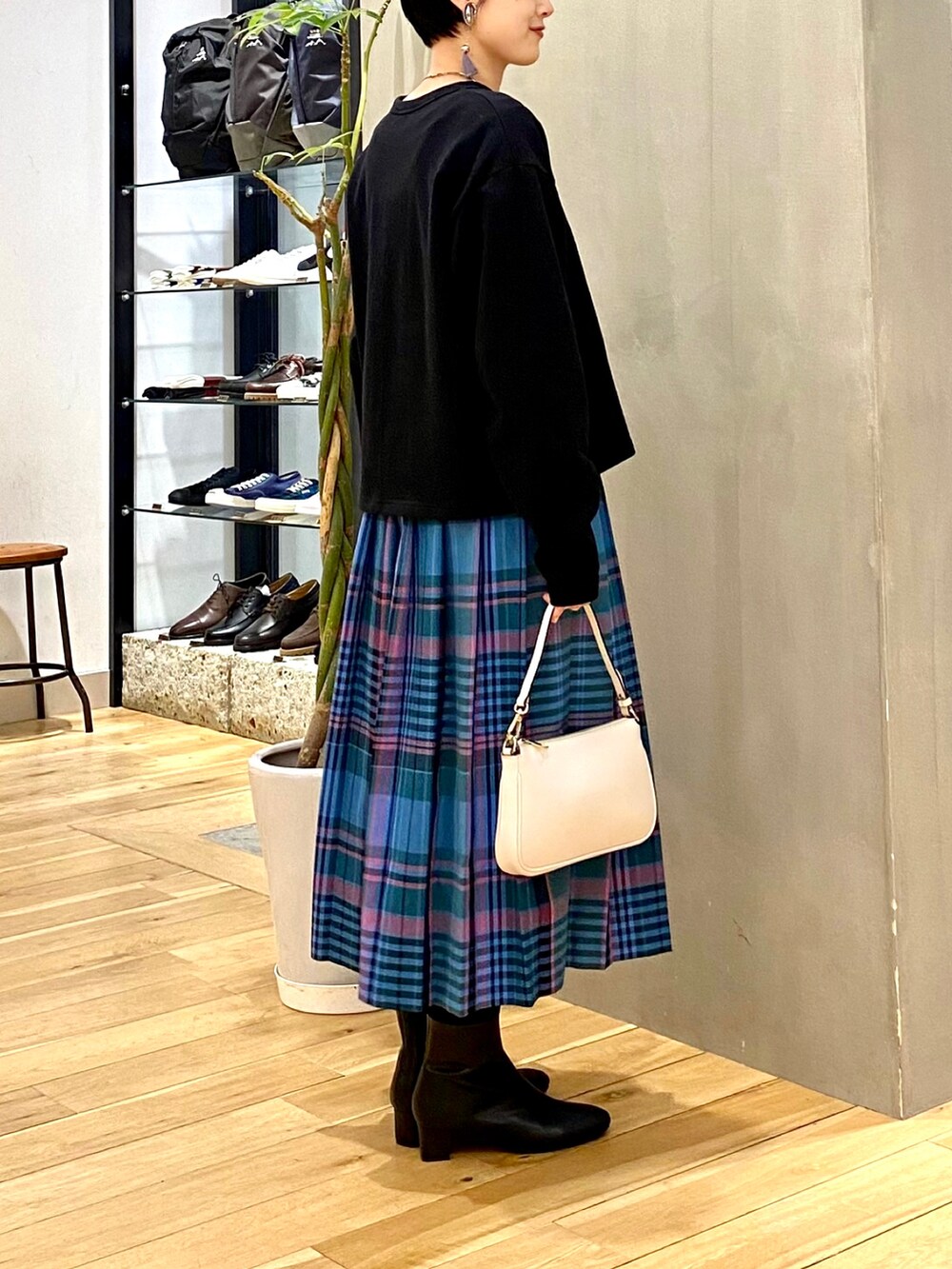 ブラック系のカーディガン/ボレロ、ブルー系のスカート、ベージュ系のショルダーバッグを着用したレディースの冬コーディネートの5枚目の写真