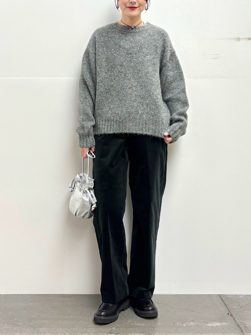 グレー系のニット/セーター、ブラック系のその他パンツ、シルバー系のショルダーバッグを着用したレディースの冬コーディネートの5枚目の写真