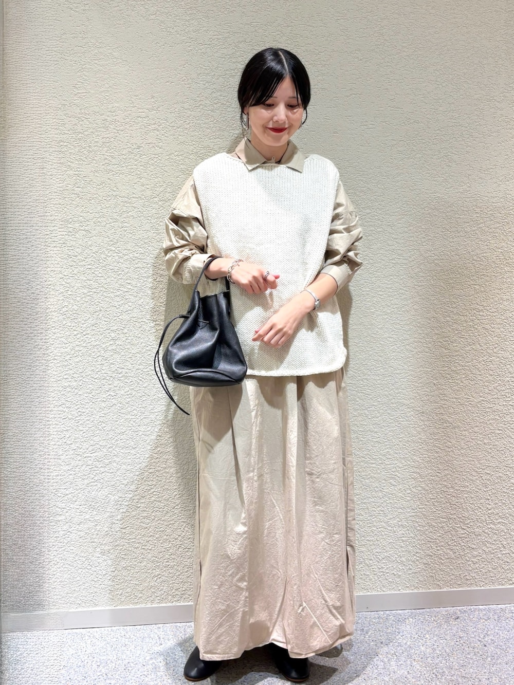 ベージュ系のワンピース、ホワイト系のニット/セーター、ブラック系のバレエシューズを着用したレディースの秋コーディネートの6枚目の写真