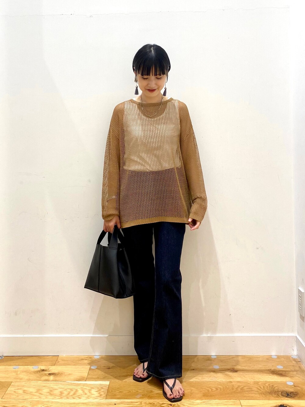 ブラウン系のニット/セーター、ホワイト系のタンクトップ、ブルー系のデニムパンツを着用したレディースの夏コーディネートの2枚目の写真