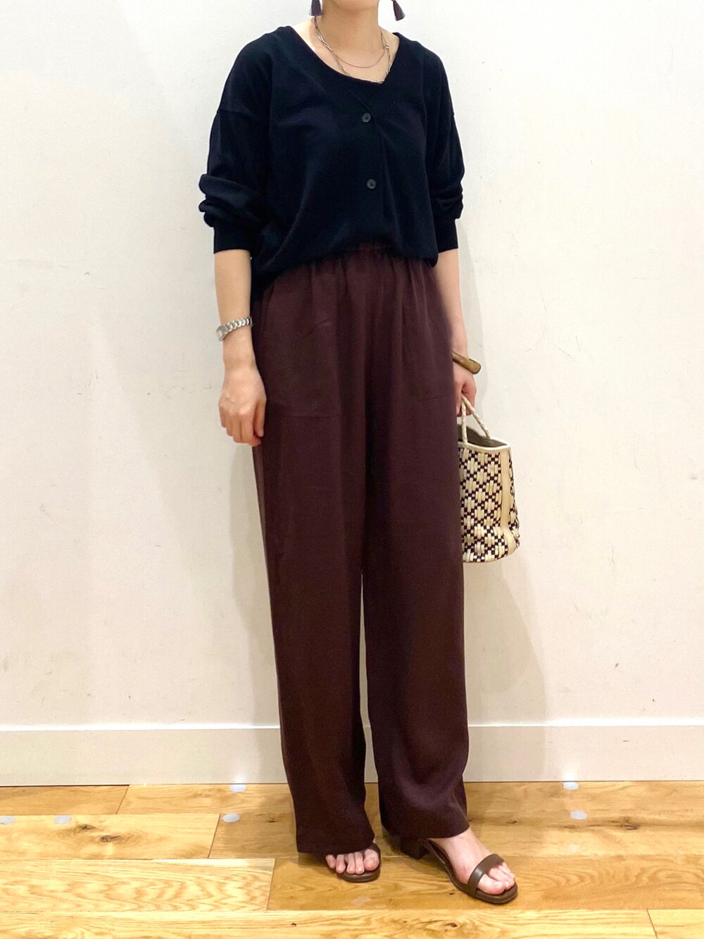 ブラック系のカーディガン/ボレロ、レッド系のその他パンツ、ブラウン系のサンダルを着用したレディースの春コーディネートの4枚目の写真