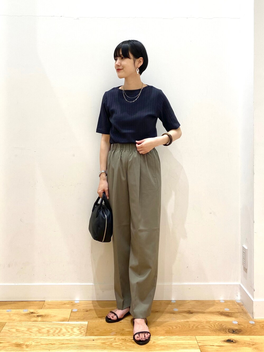 ブラック系のTシャツ/カットソー、グリーン系のその他パンツ、ブラック系のボストンバッグを着用したレディースの夏コーディネートの2枚目の写真