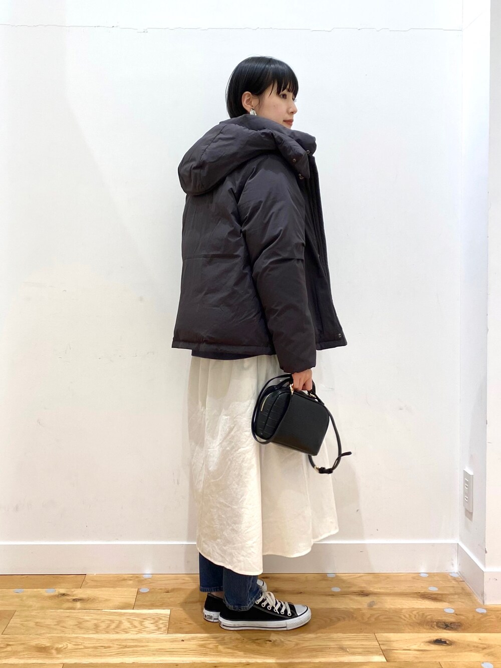 ブラック系のダウンジャケット/コート、ブルー系のスウェット、ホワイト系のワンピースを着用したレディースの冬コーディネートの2枚目の写真