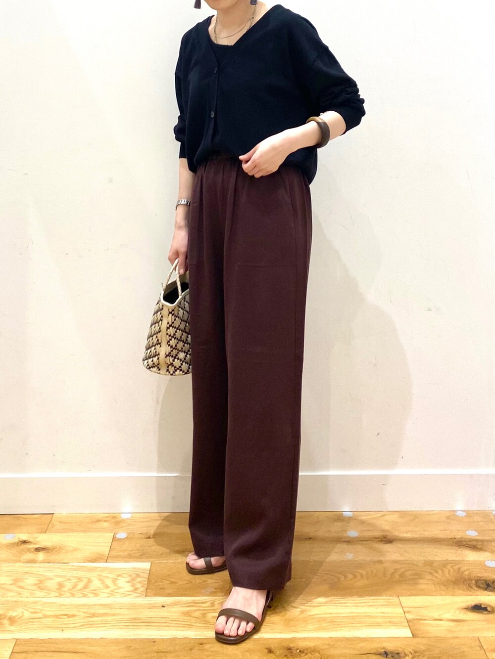 ブラック系のカーディガン/ボレロ、レッド系のその他パンツ、ブラウン系のサンダルを着用したレディースの春コーディネートの5枚目の写真