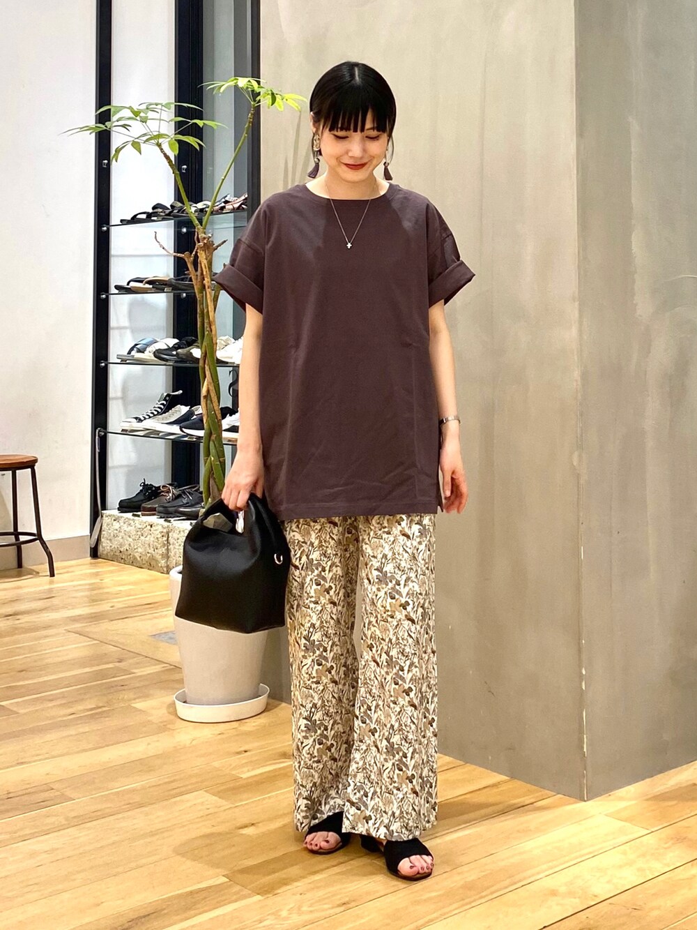 グレー系のTシャツ/カットソー、ホワイト系のその他パンツ、ブラック系のハンドバッグを着用したレディースの夏コーディネートの2枚目の写真