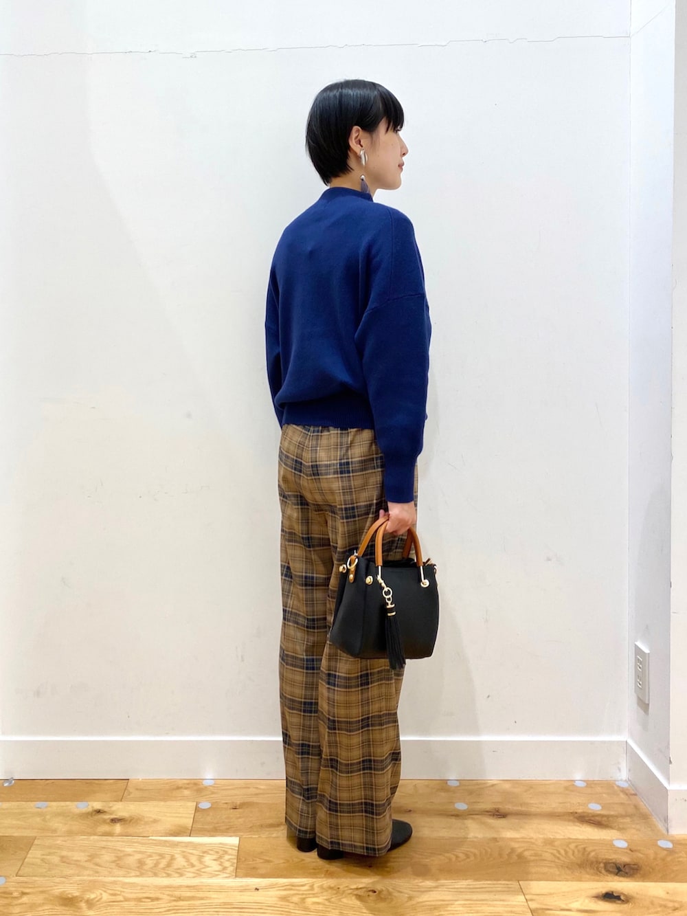 グレー系のチェスターコート、ブルー系のニット/セーター、ベージュ系のその他パンツを着用したレディースの秋コーディネートの4枚目の写真