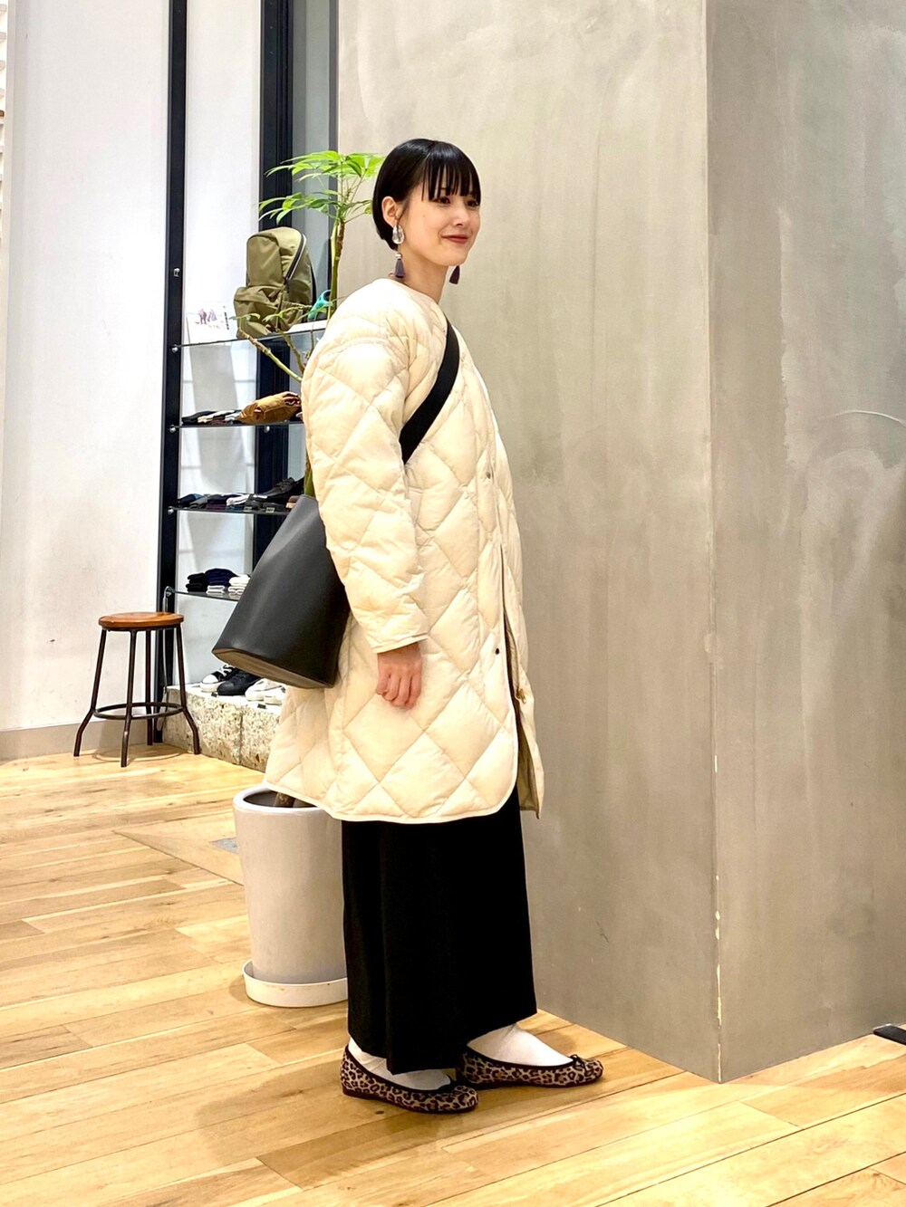 ベージュ系のダウンジャケット/コート、レッド系のTシャツ/カットソー、ブラック系のスカートを着用したレディースの秋コーディネートの2枚目の写真