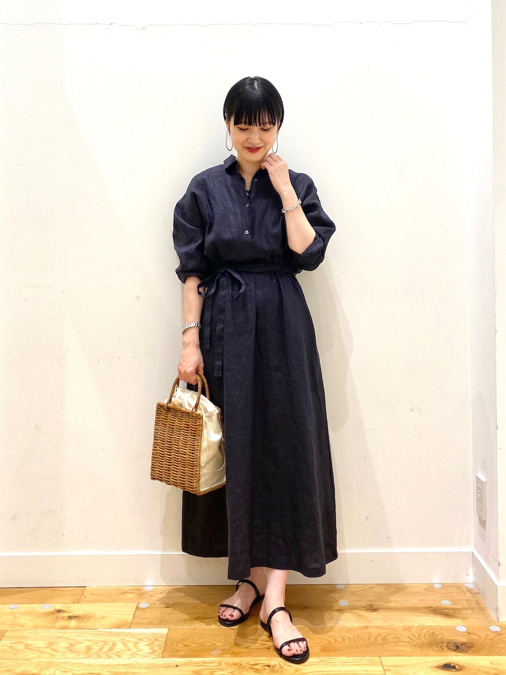 ブルー系のワンピース、ホワイト系のハンドバッグ、ブラック系のサンダルを着用したレディースの夏コーディネートの2枚目の写真