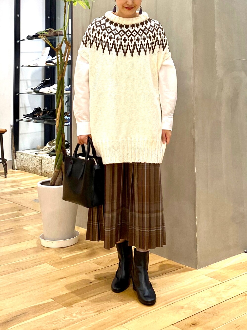 ホワイト系のニット/セーター、ホワイト系のシャツ/ブラウス、ブラウン系のスカートを着用したレディースの秋コーディネートの3枚目の写真