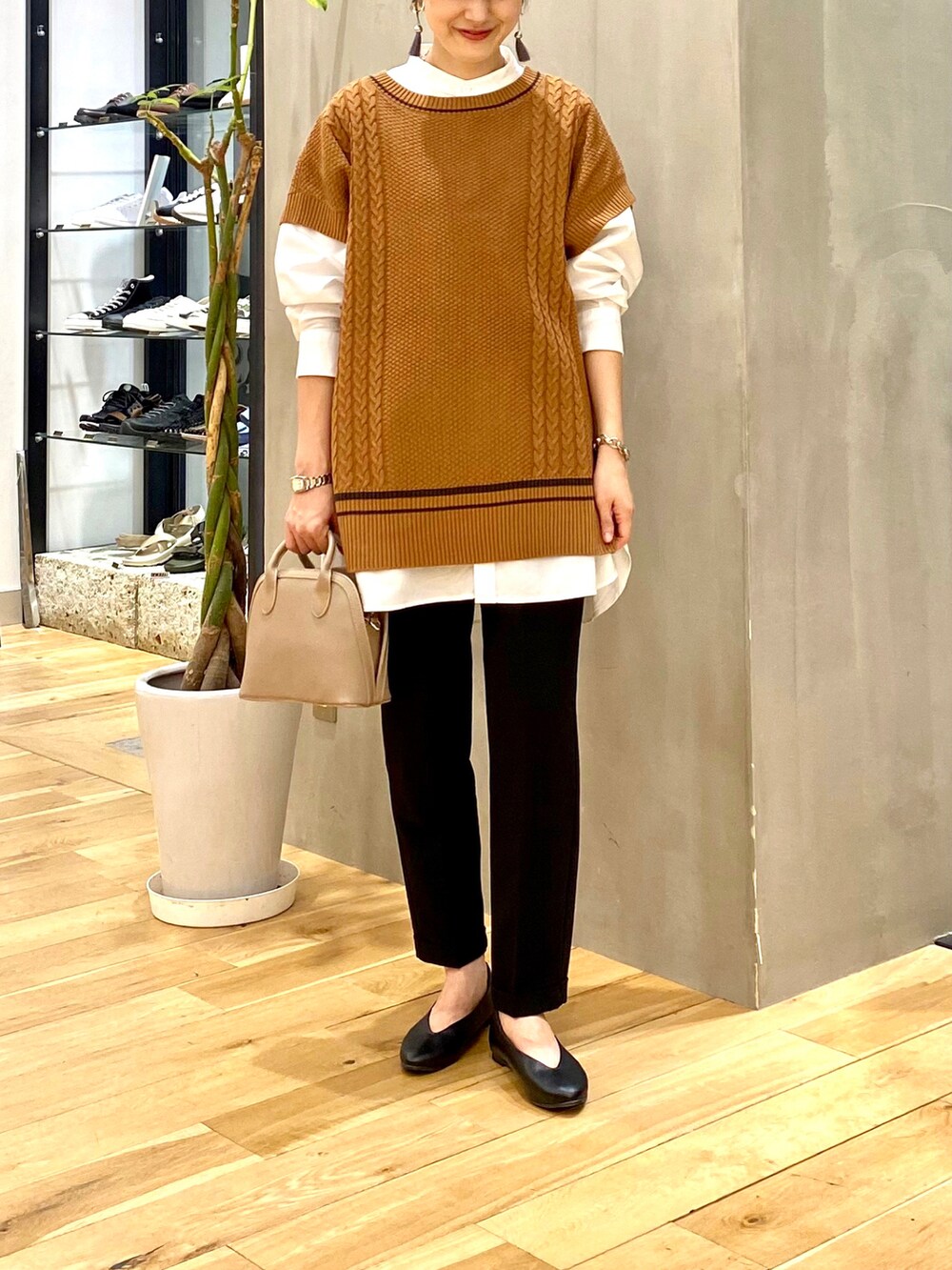 ホワイト系のシャツ/ブラウス、イエロー系のニット/セーター、ブラック系のその他パンツを着用したレディースの秋コーディネートの4枚目の写真