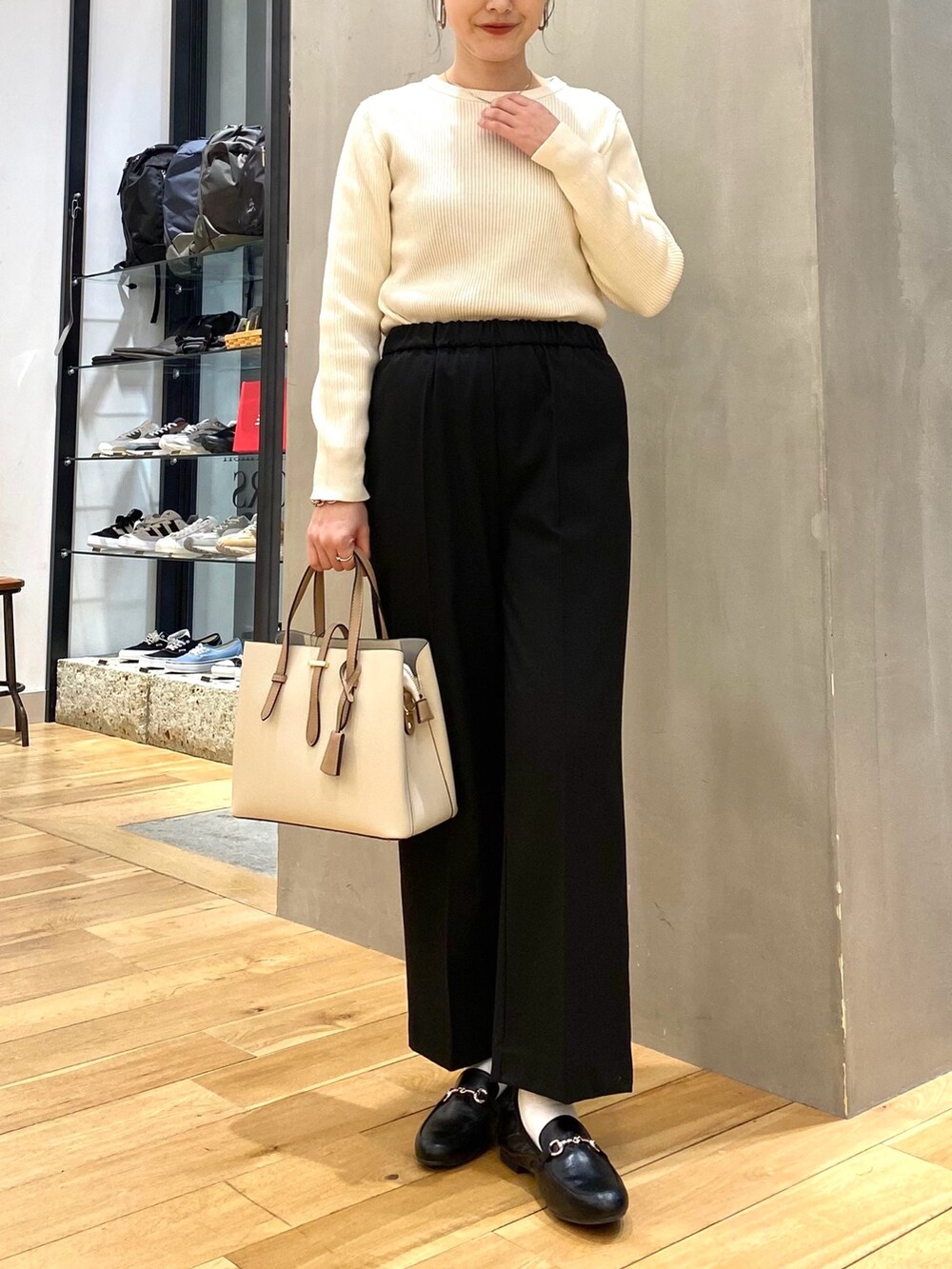 ホワイト系のニット/セーター、ブラック系のその他パンツ、ホワイト系のトートバッグを着用したレディースの冬コーディネートの7枚目の写真
