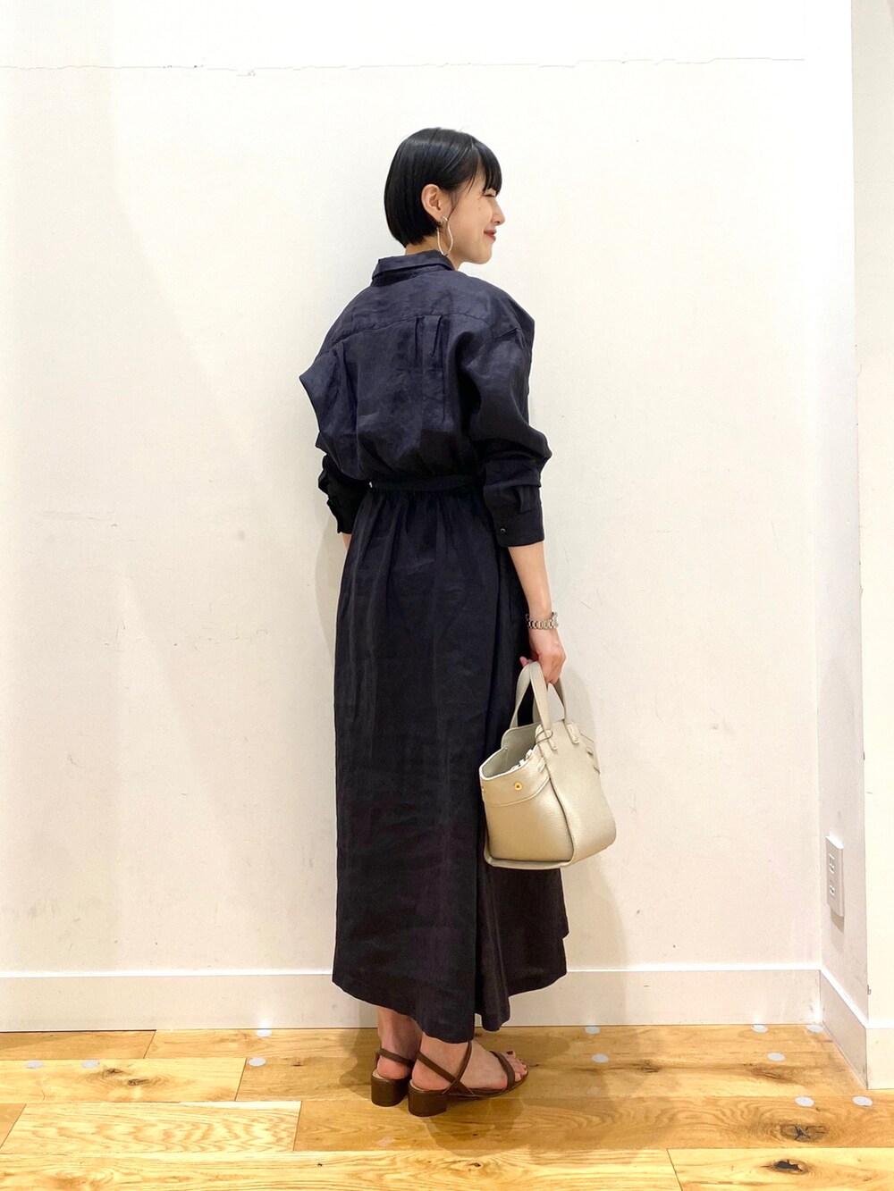 ブルー系のワンピース、ホワイト系のワンピース、ホワイト系のハンドバッグを着用したレディースの春コーディネートの3枚目の写真