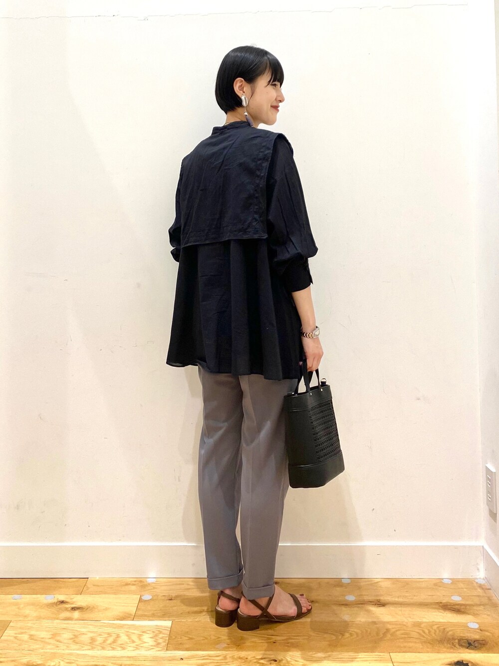ブルー系のその他パンツ、ブラウン系のサンダル、ブラック系のシャツ/ブラウスを着用したレディースの春コーディネートの3枚目の写真