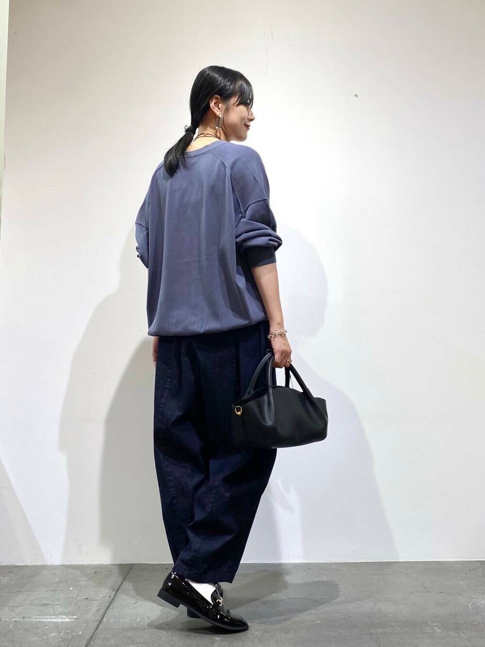 ブラック系のローファー、ブルー系のデニムパンツ、ブルー系のカーディガン/ボレロを着用したレディースの秋コーディネートの4枚目の写真