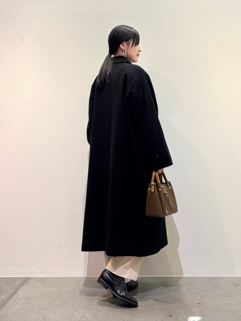 ブラック系のその他アウター、ベージュ系のニット/セーター、ホワイト系のその他パンツを着用したレディースの冬コーディネートの3枚目の写真