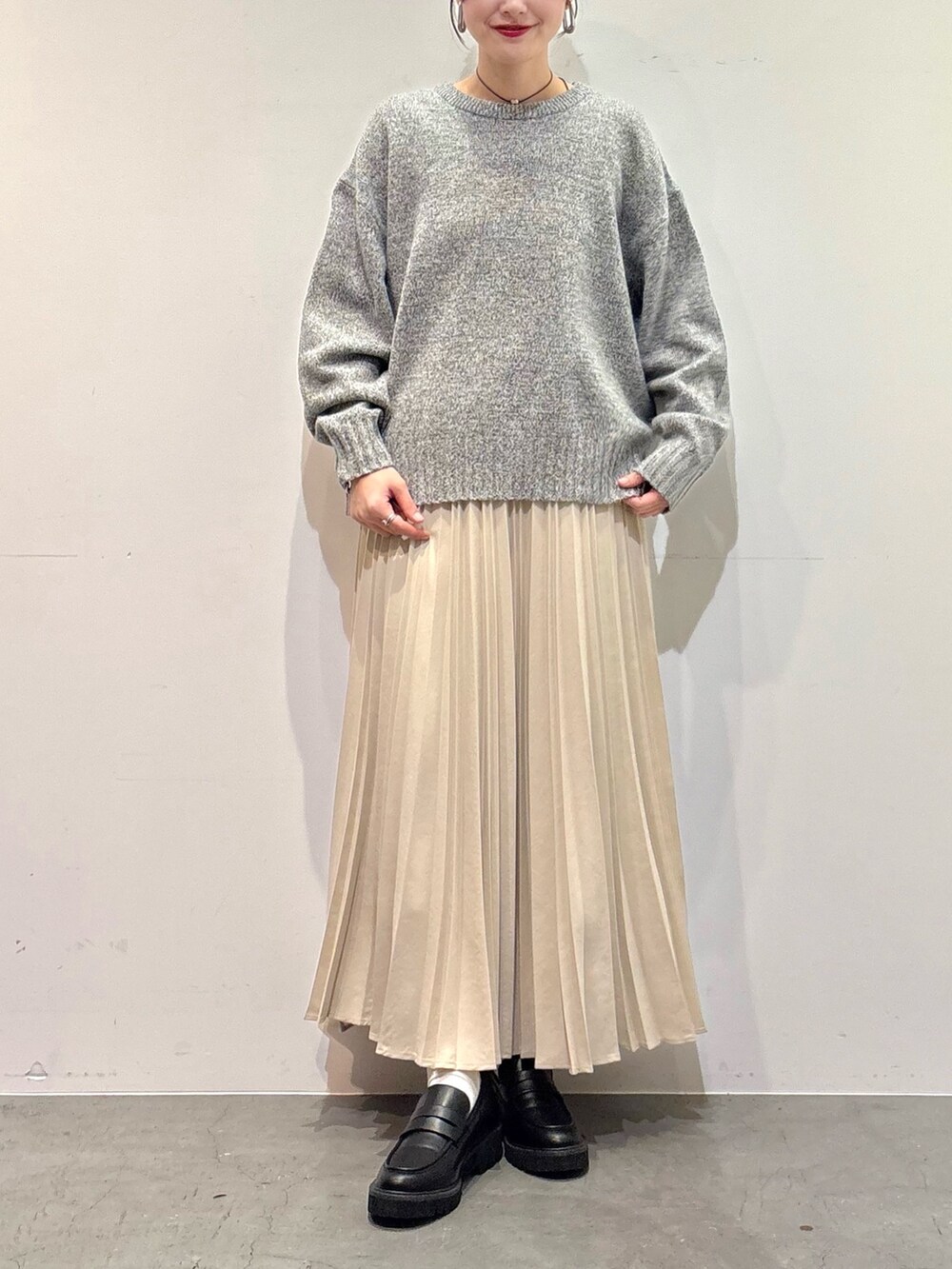 グレー系のニット/セーター、ホワイト系のスカート、ブラック系のローファーを着用したレディースの冬コーディネートの4枚目の写真