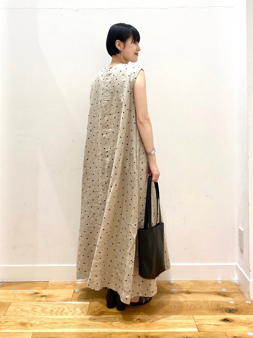 グレー系のカーディガン/ボレロ、ベージュ系のワンピース、ブラック系のトートバッグを着用したレディースの春コーディネートの4枚目の写真