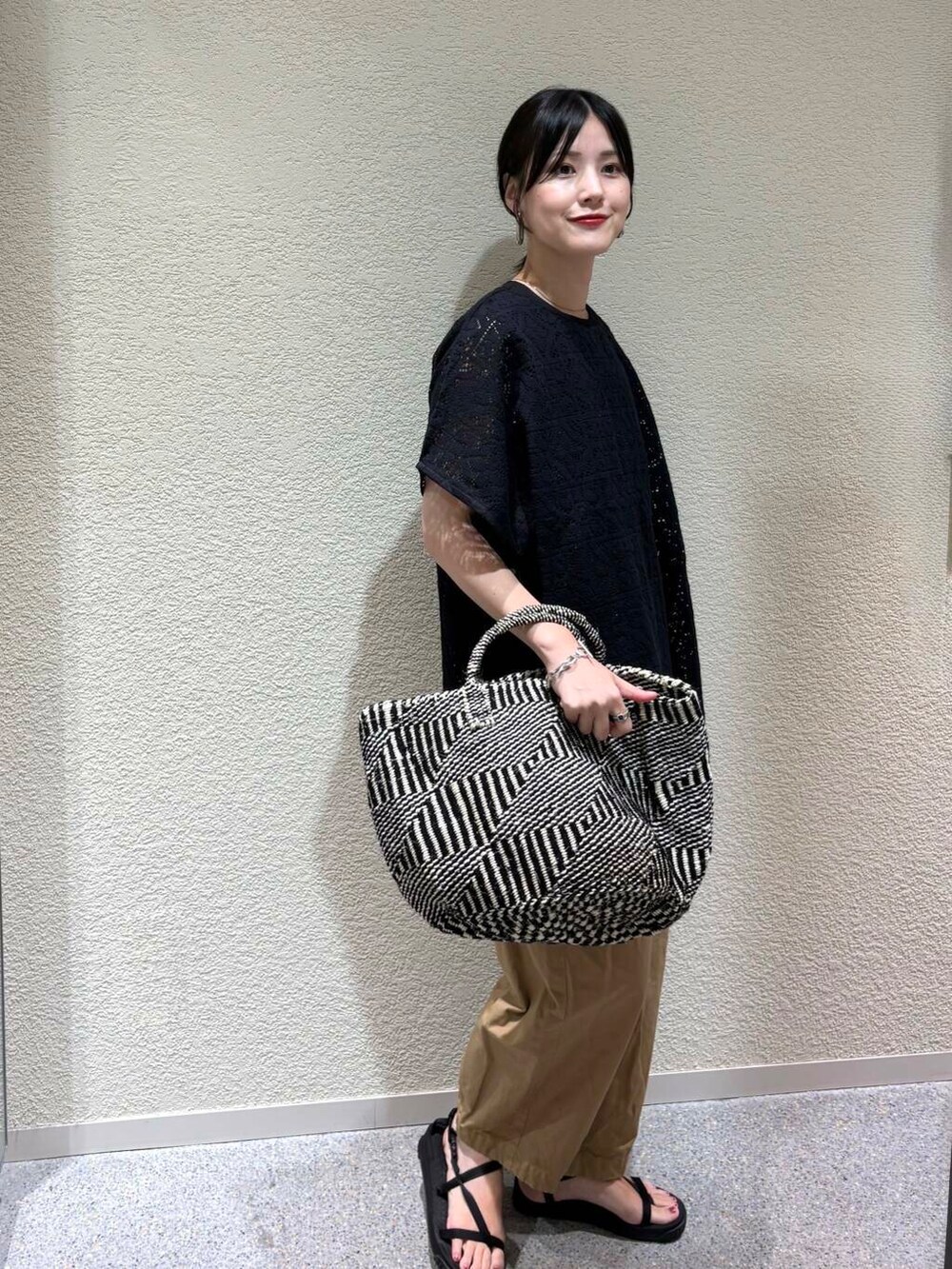 ベージュ系のその他パンツ、ブラック系のTシャツ/カットソーを着用したレディースの夏コーディネートの2枚目の写真