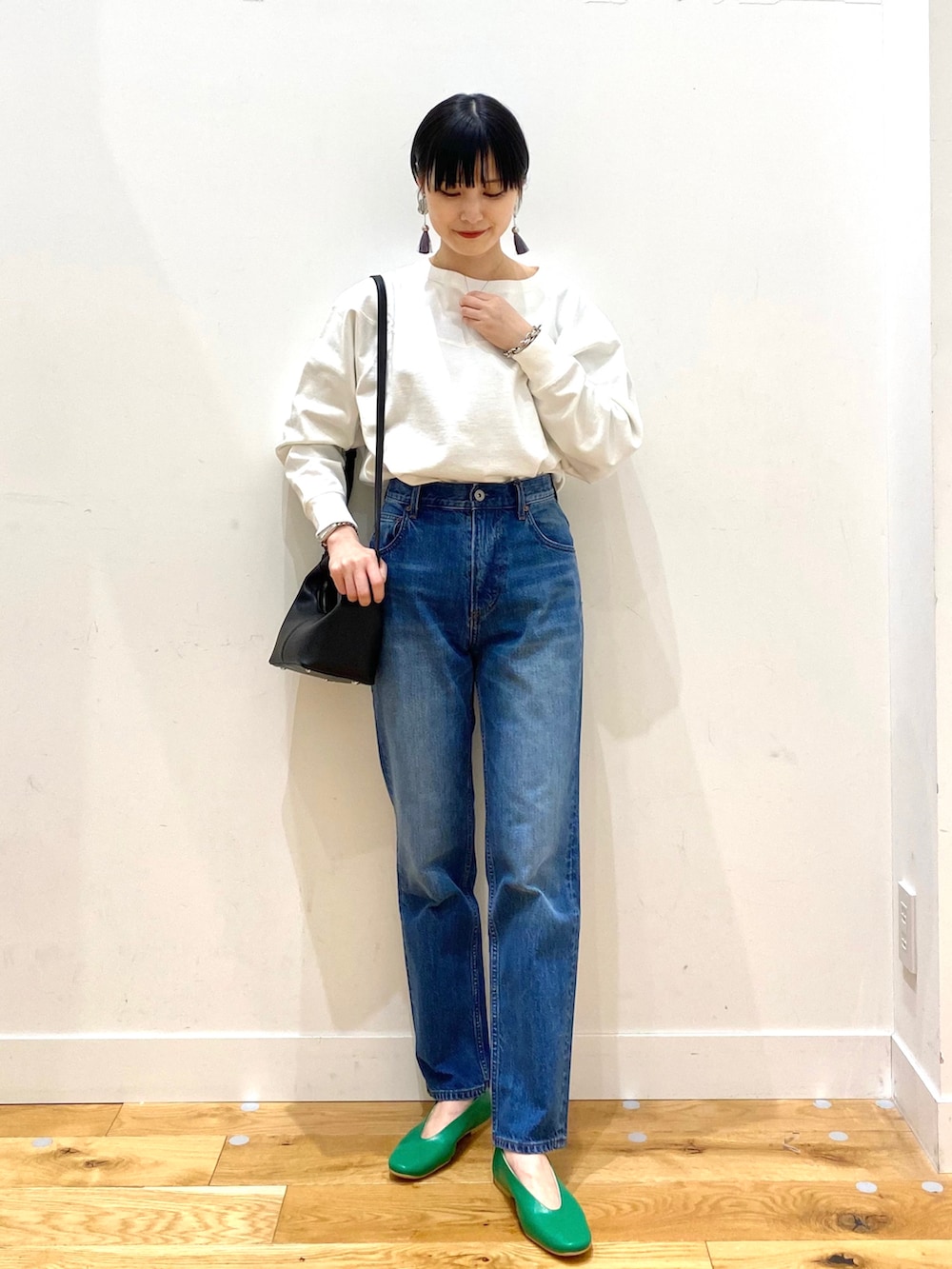 ベージュ系のステンカラーコート、ホワイト系のTシャツ/カットソー、ブルー系のデニムパンツを着用したレディースの春コーディネートの3枚目の写真