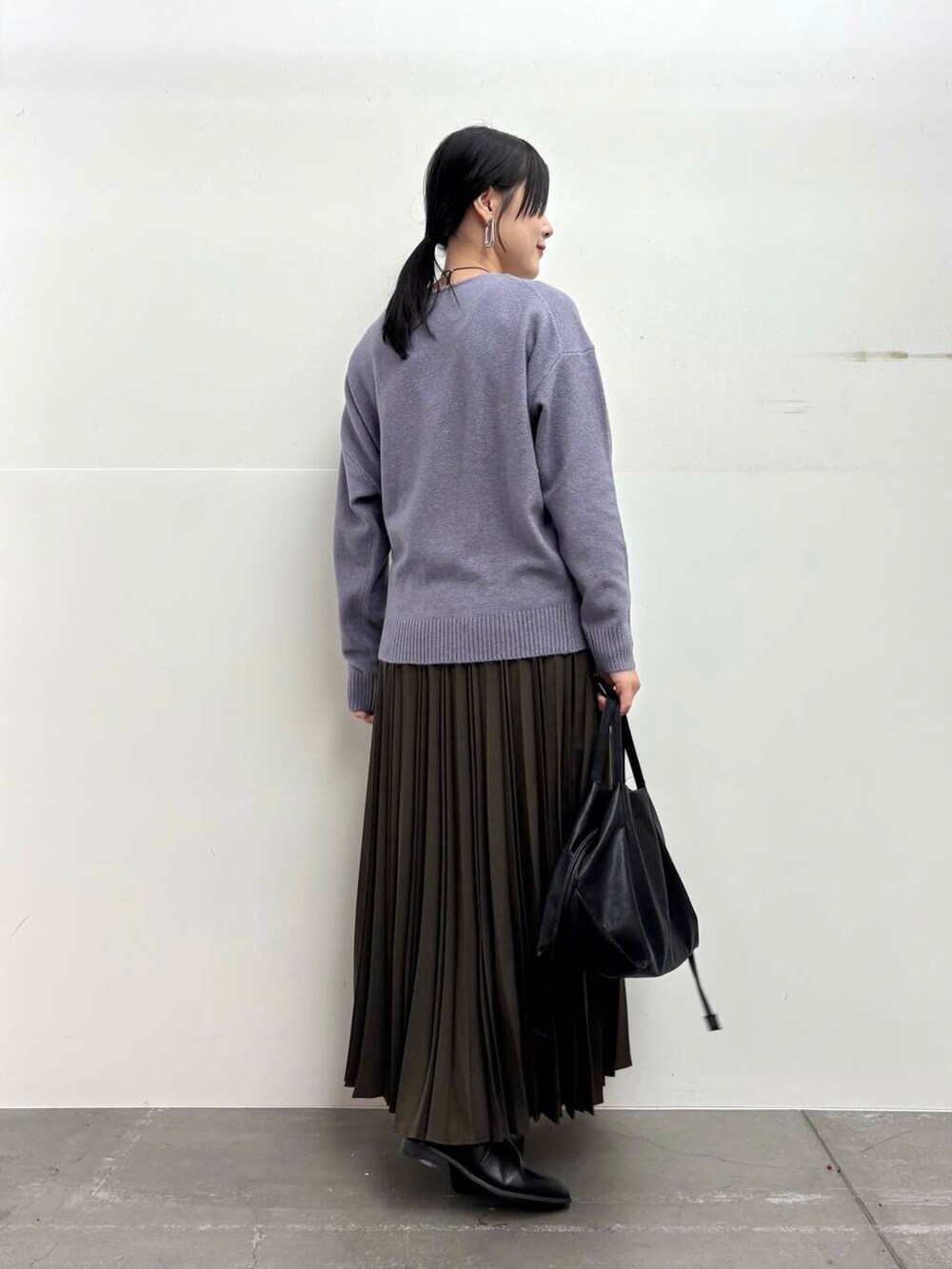 ブラック系のショルダーバッグ、ホワイト系のダウンジャケット/コート、ブラック系のブーツを着用したレディースの冬コーディネートの6枚目の写真