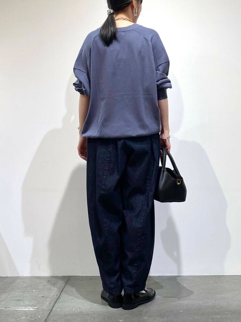 ブラック系のローファー、ブルー系のデニムパンツ、ブルー系のカーディガン/ボレロを着用したレディースの秋コーディネートの7枚目の写真