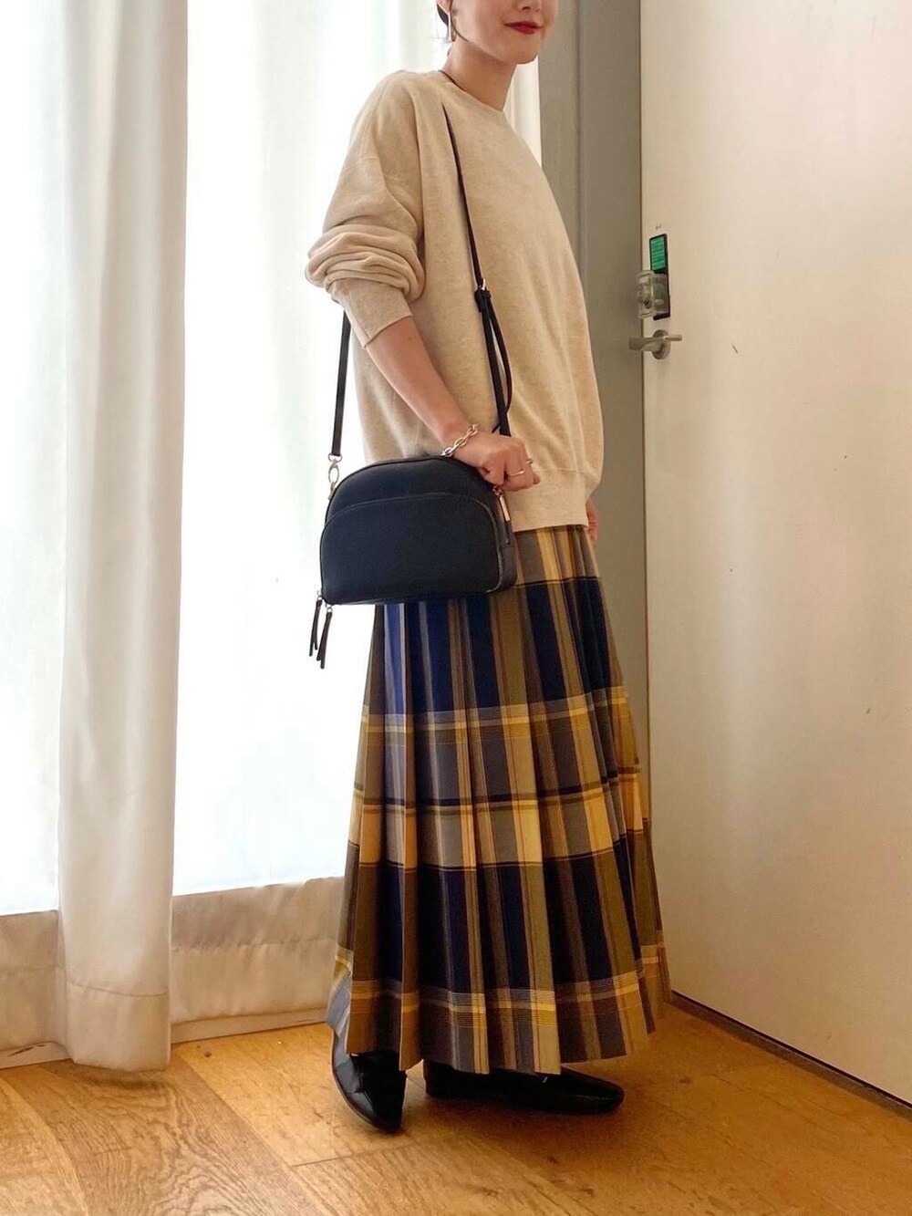 ブラック系のローファー、ブラック系のショルダーバッグ、ブルー系のスカートを着用したレディースの秋コーディネートの6枚目の写真