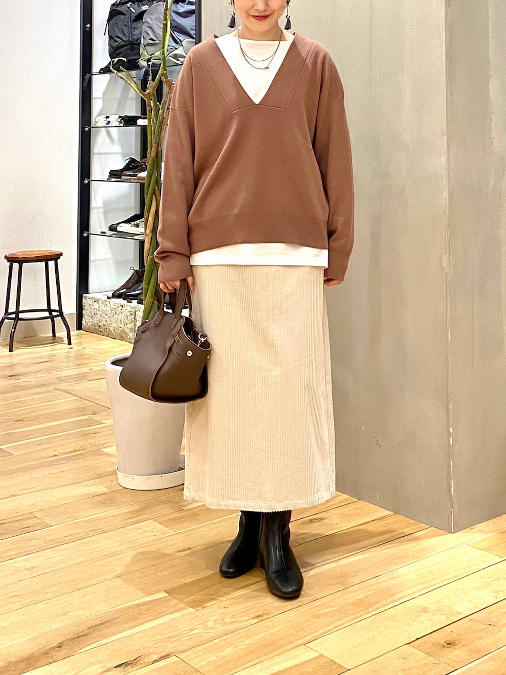 ブラウン系のニット/セーター、ホワイト系のTシャツ/カットソー、ホワイト系のスカートを着用したレディースの冬コーディネートの4枚目の写真