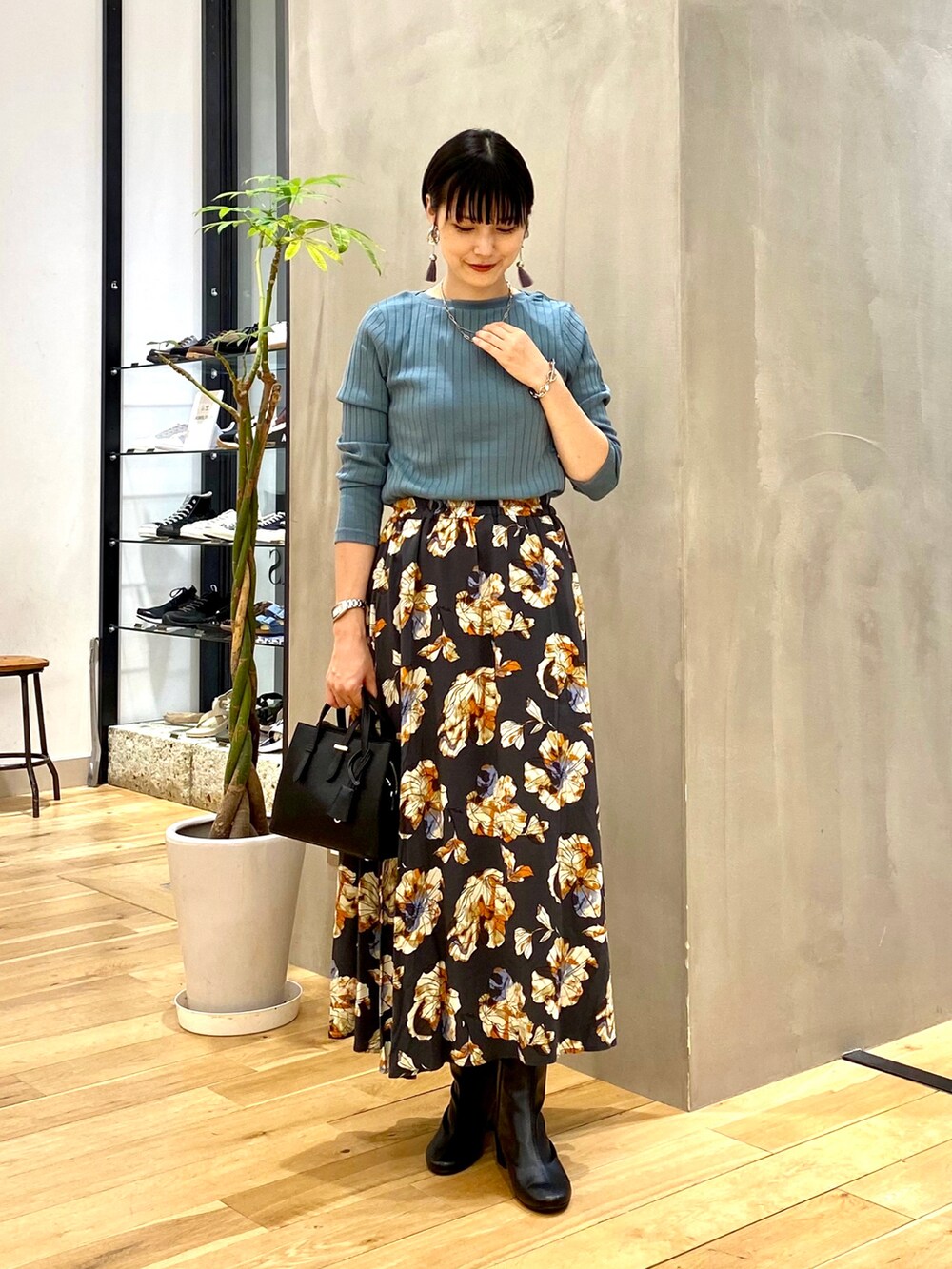 ブルー系のTシャツ/カットソー、グレー系のスカート、ブラック系のトートバッグを着用したレディースの秋コーディネートの2枚目の写真