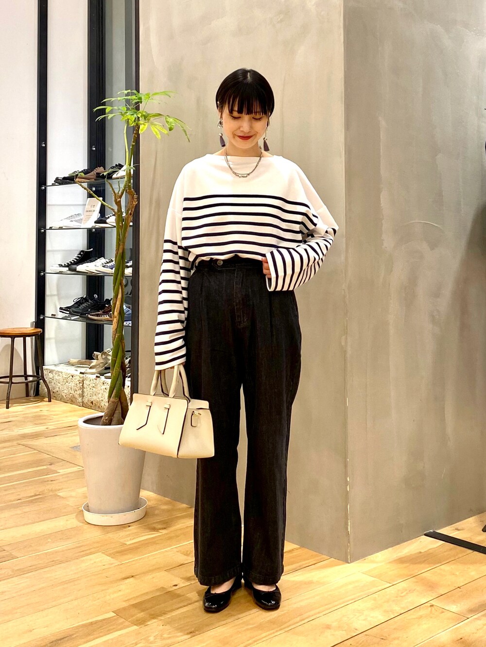 ブラウン系のカーディガン/ボレロ、ブルー系のTシャツ/カットソー、ブラック系のデニムパンツを着用したレディースの秋コーディネートの3枚目の写真