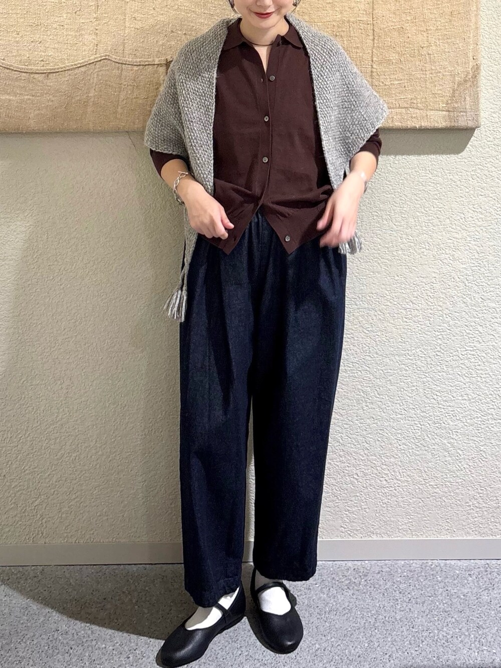 ブラウン系のニット/セーター、ブラウン系のニット/セーター、ブルー系のデニムパンツを着用したレディースの秋コーディネートの4枚目の写真