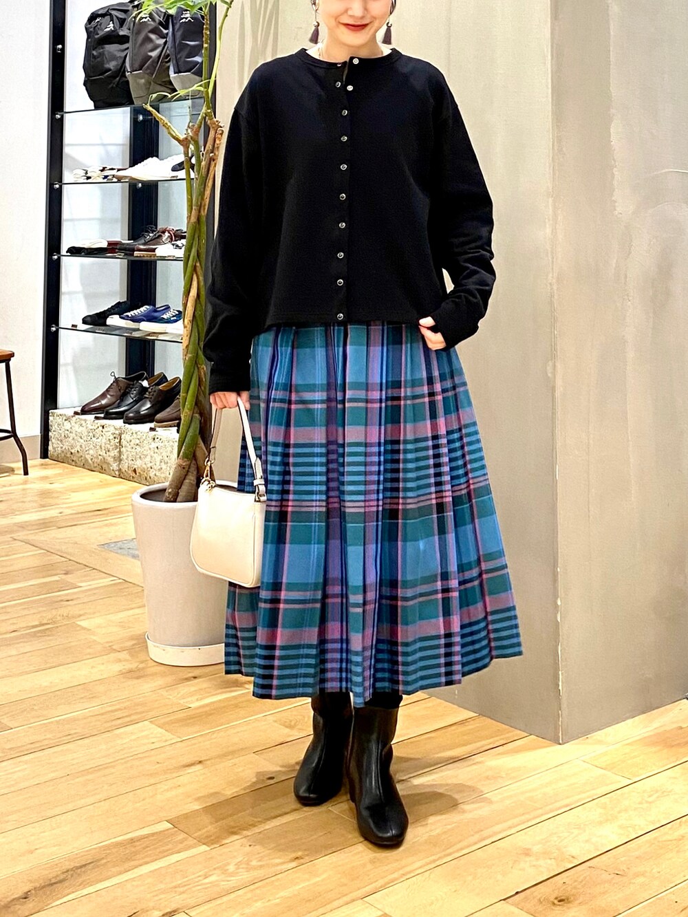 ブラック系のカーディガン/ボレロ、ブルー系のスカート、ベージュ系のショルダーバッグを着用したレディースの冬コーディネートの4枚目の写真