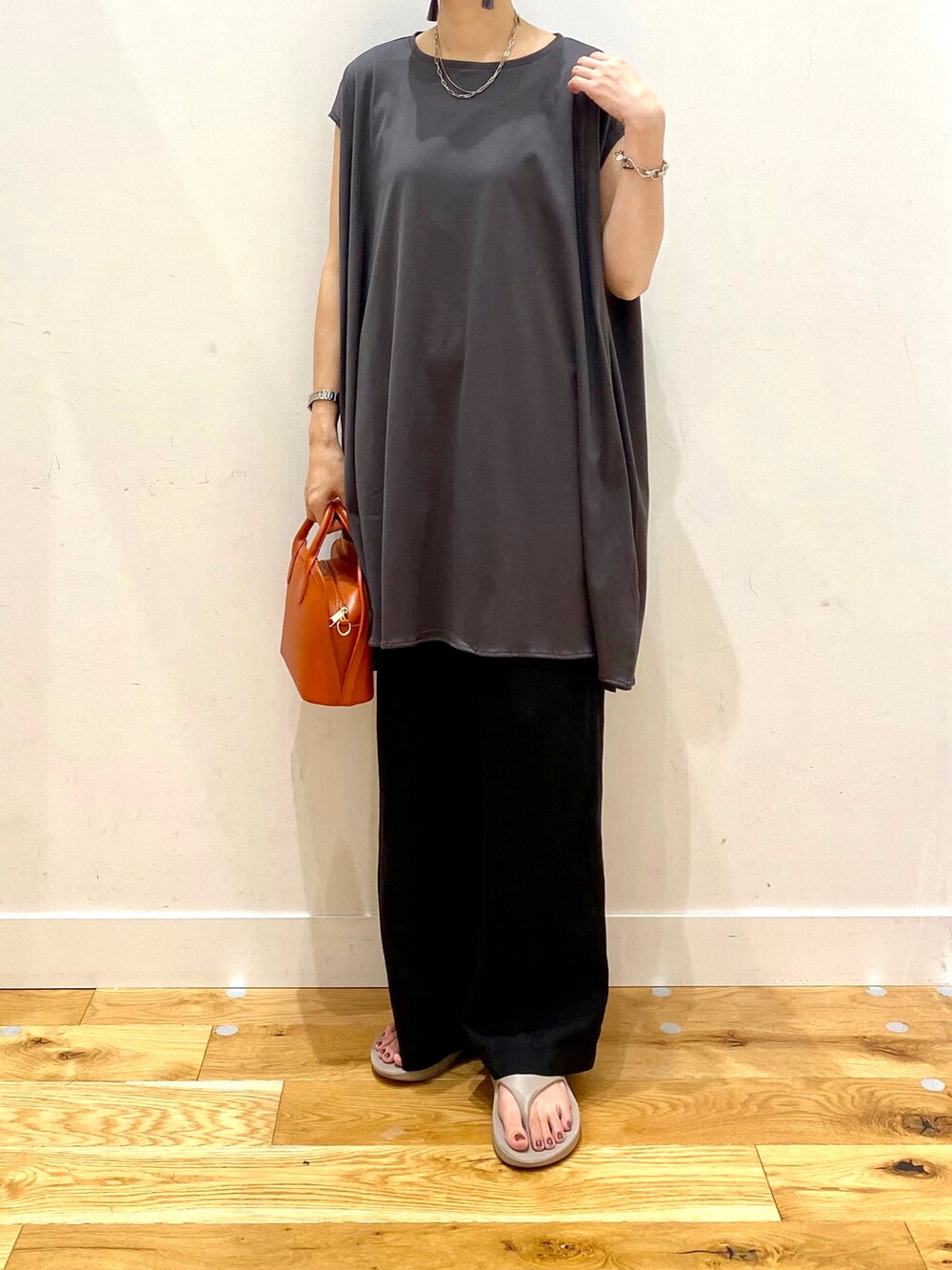 グレー系のTシャツ/カットソー、ブラック系のその他パンツ、オレンジ系のショルダーバッグを着用したレディースの夏コーディネートの4枚目の写真