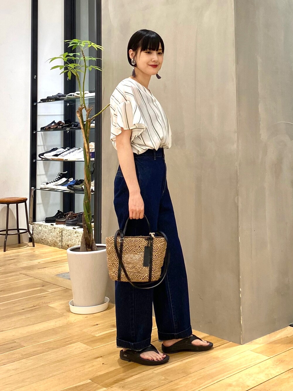 グリーン系のシャツ/ブラウス、ブルー系のデニムパンツ、ブラック系のサンダルを着用したレディースの春コーディネートの3枚目の写真