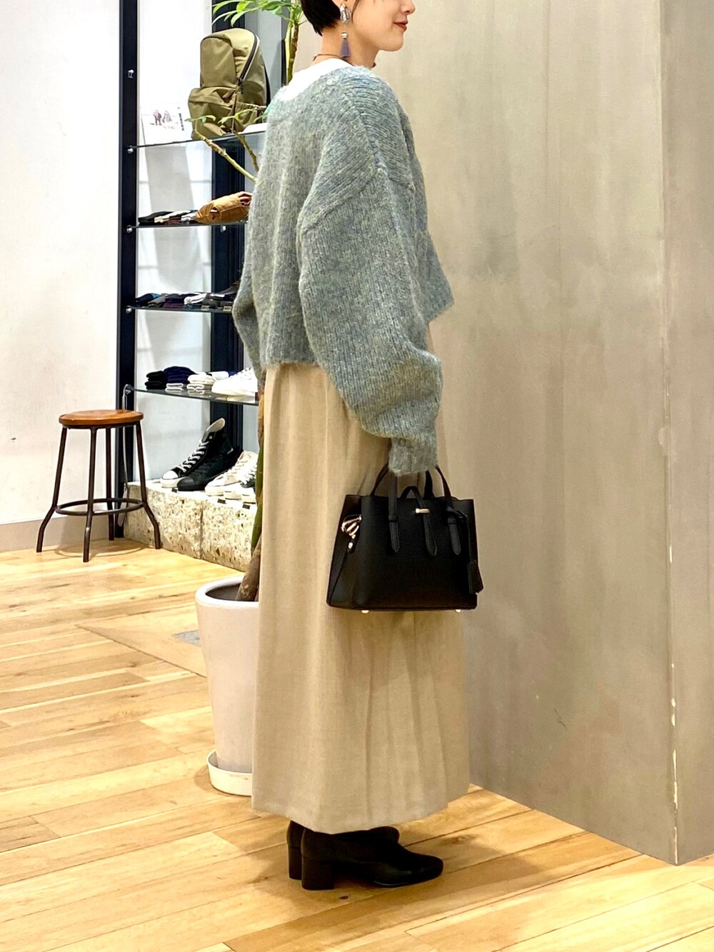 ブルー系のカーディガン/ボレロ、ホワイト系のTシャツ/カットソー、ベージュ系のスカートを着用したレディースの秋コーディネートの5枚目の写真