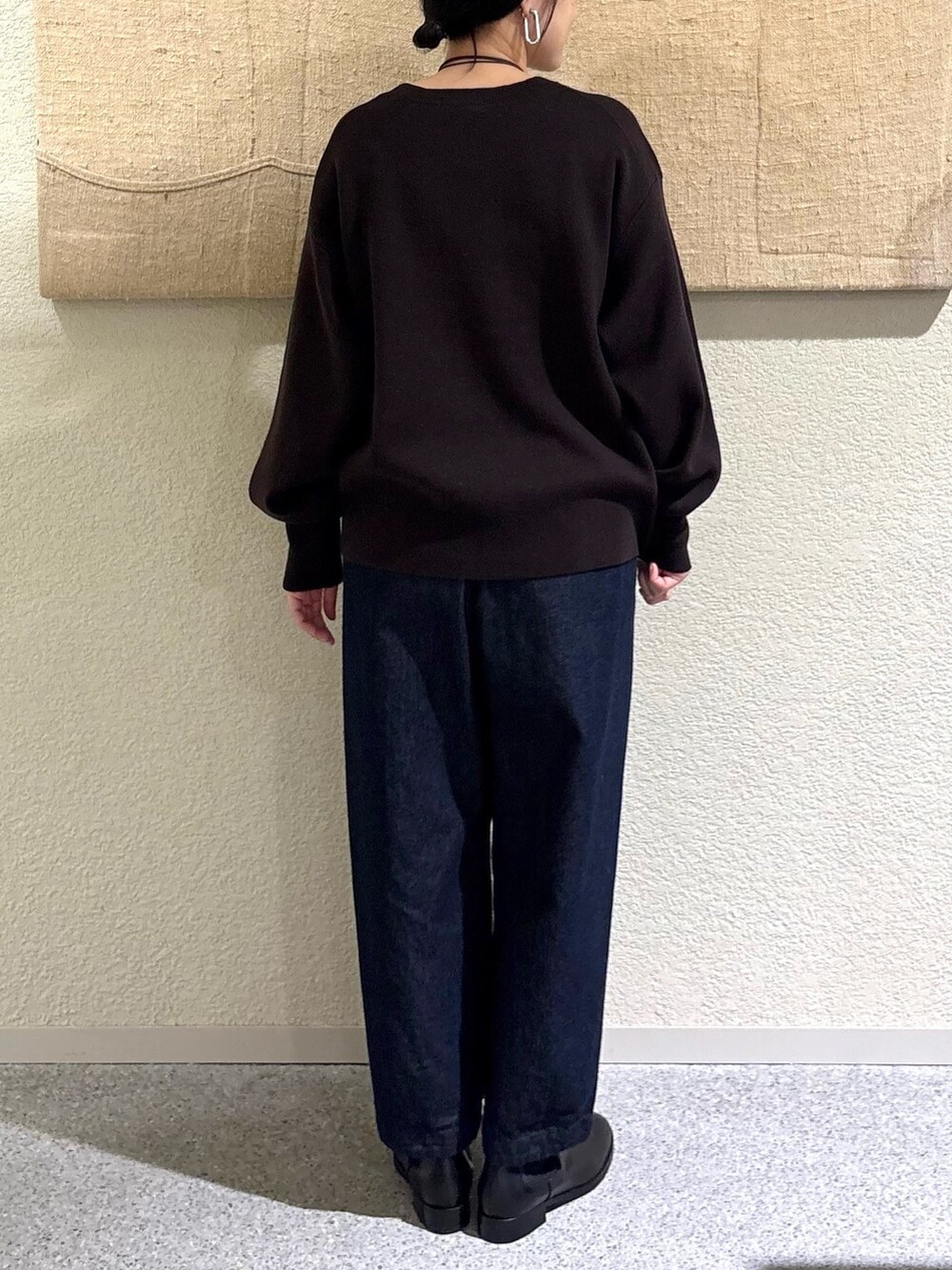 ブラウン系のニット/セーター、ブラウン系のニット/セーター、ブルー系のデニムパンツを着用したレディースの秋コーディネートの5枚目の写真