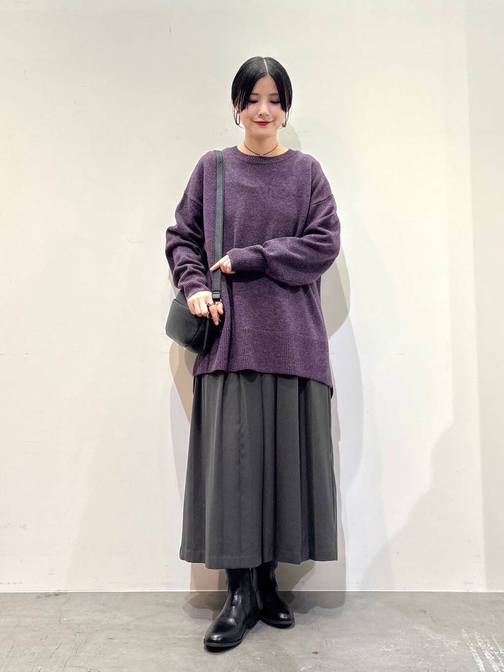 ブラック系のショルダーバッグ、グレー系のスカート、ブラック系のブーツを着用したレディースの冬コーディネートの4枚目の写真