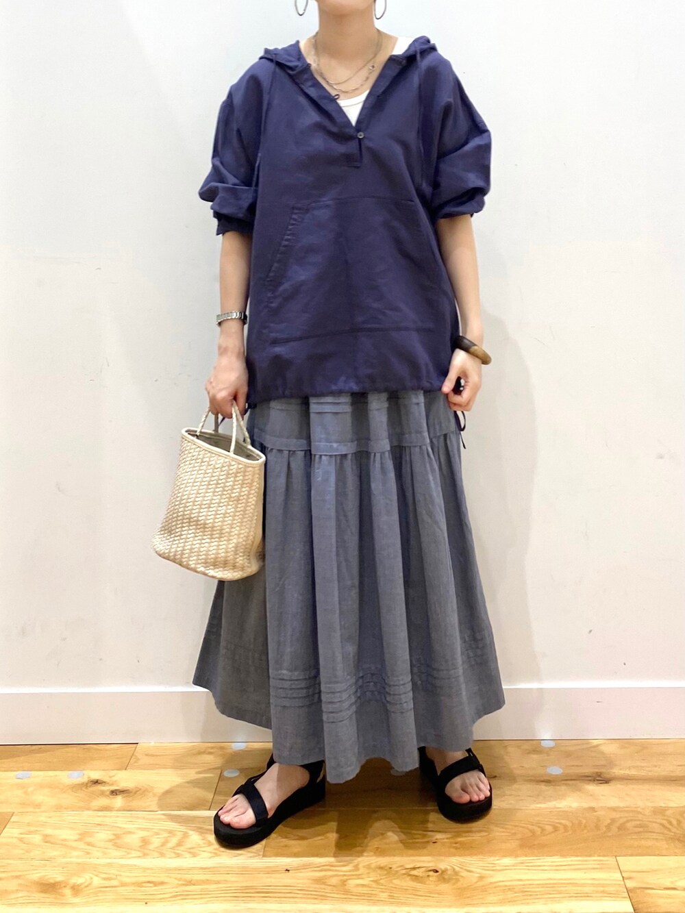 ブルー系のパーカー、ホワイト系のタンクトップ、グレー系のスカートを着用したレディースの春コーディネートの4枚目の写真