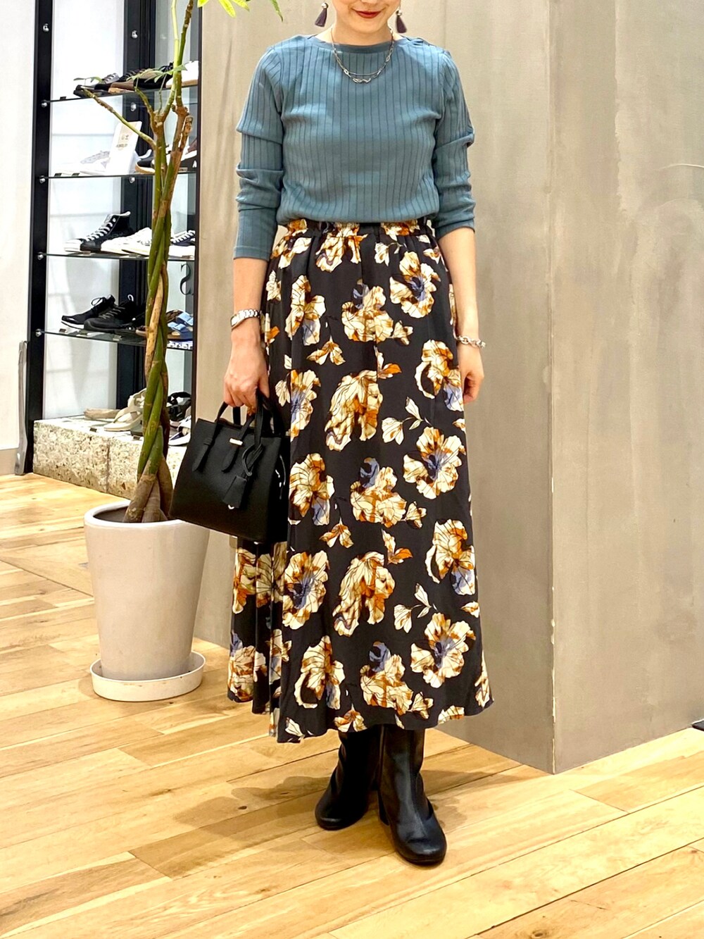 ブルー系のTシャツ/カットソー、グレー系のスカート、ブラック系のトートバッグを着用したレディースの秋コーディネートの4枚目の写真