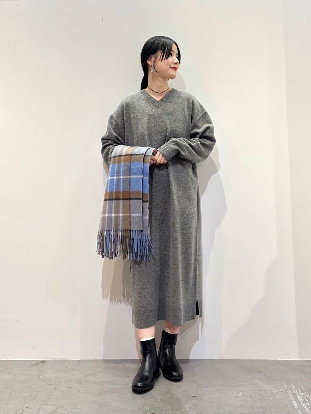 ブラック系のダウンジャケット/コート、ブラック系のブーツ、グレー系のワンピースを着用したレディースの冬コーディネートの4枚目の写真