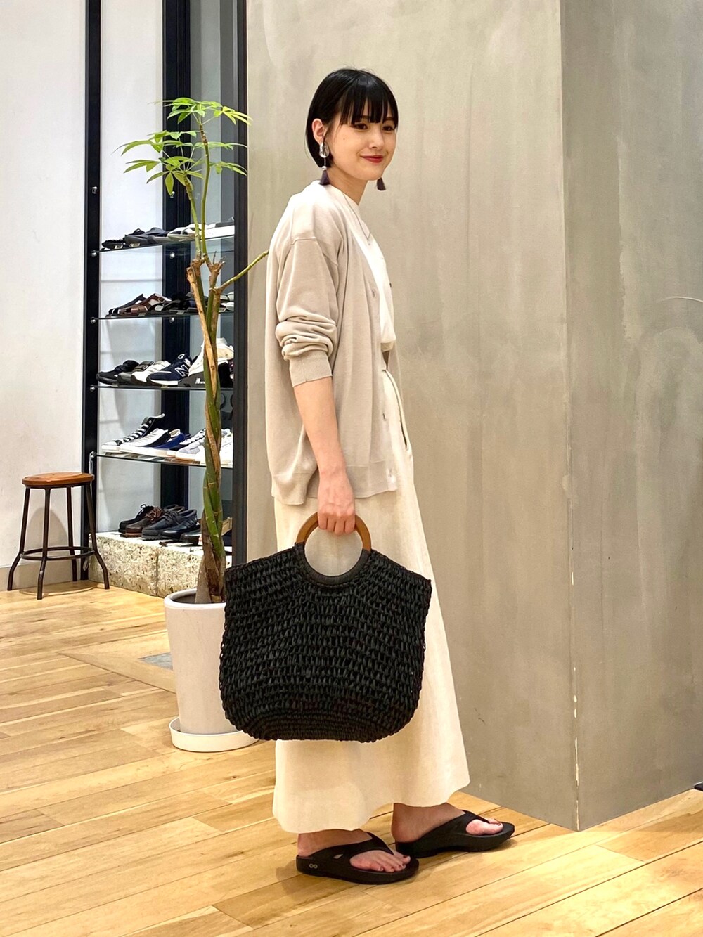 グレー系のカーディガン/ボレロ、ホワイト系のTシャツ/カットソー、ベージュ系のスカートを着用したレディースの春コーディネートの4枚目の写真