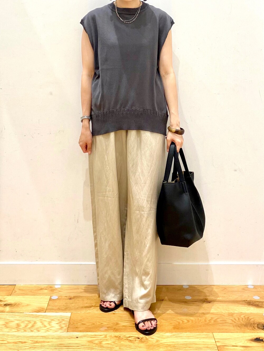 グレー系のニット/セーター、ベージュ系のその他パンツ、ブラック系のトートバッグを着用したレディースの夏コーディネートの4枚目の写真