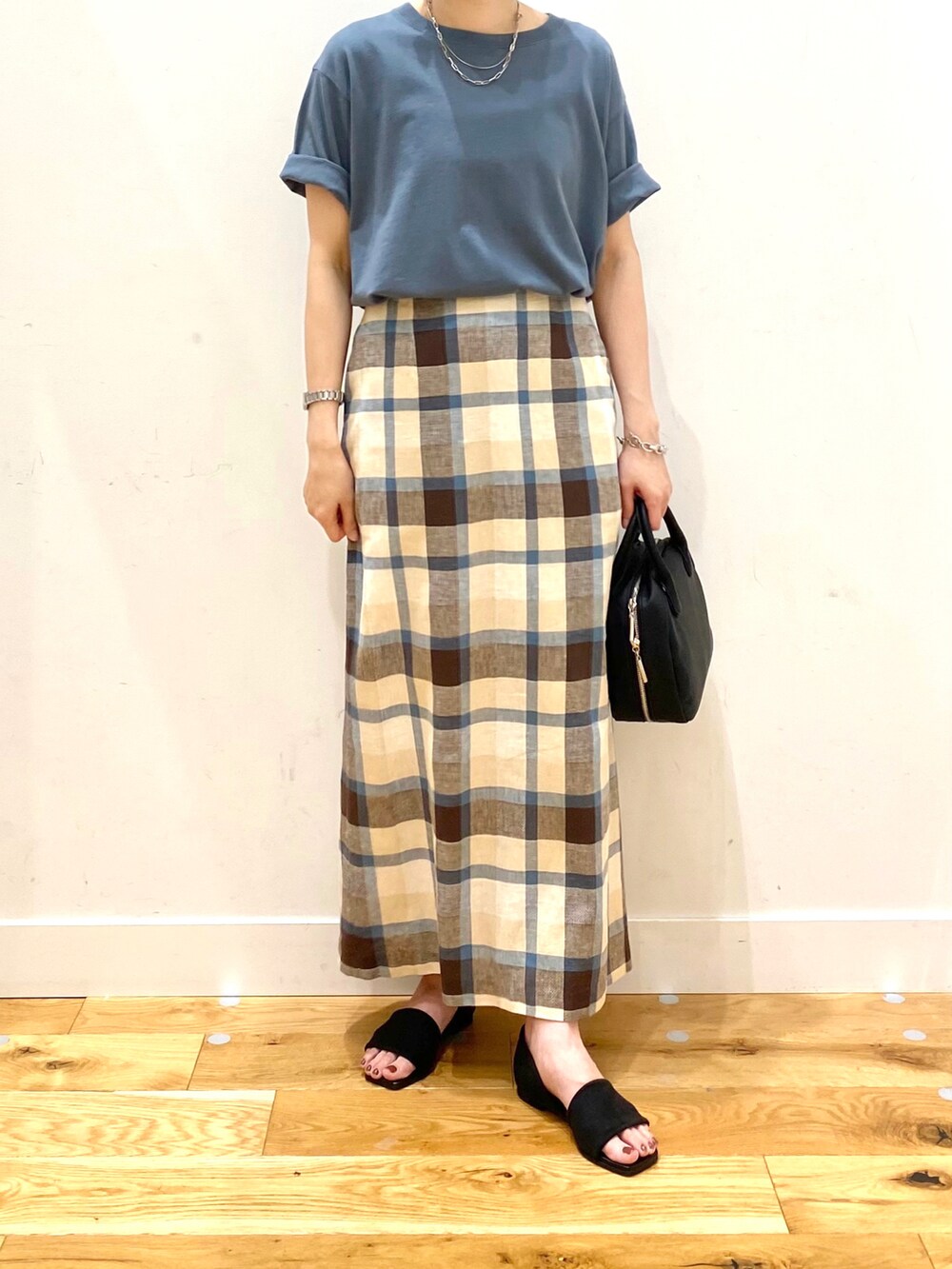 ブルー系のTシャツ/カットソー、ブルー系のスカート、ブラック系のボストンバッグを着用したレディースの夏コーディネートの4枚目の写真