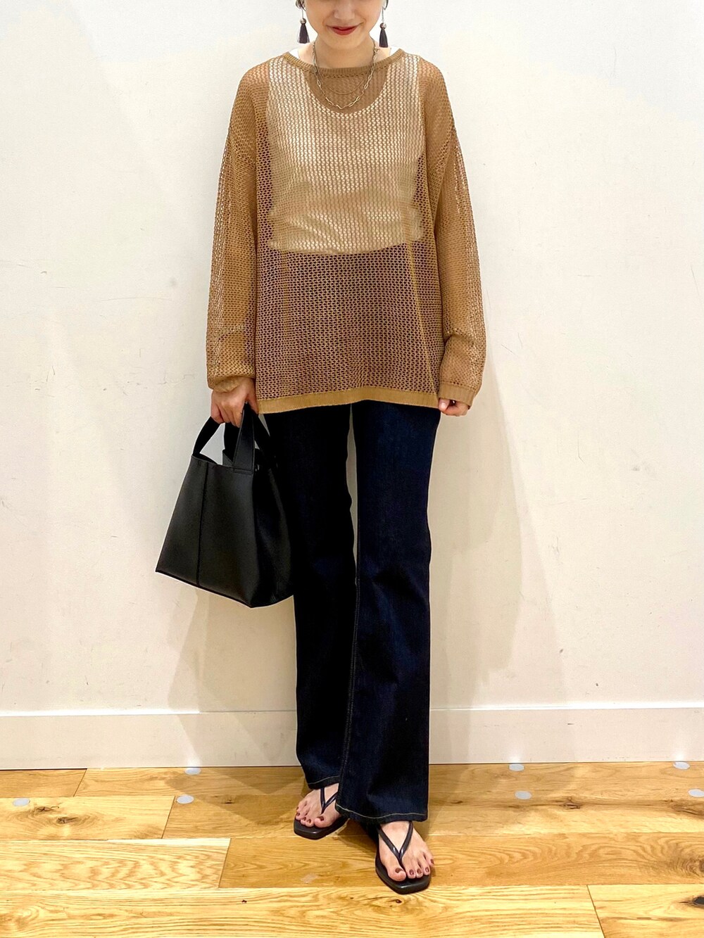 ブラウン系のニット/セーター、ホワイト系のタンクトップ、ブルー系のデニムパンツを着用したレディースの夏コーディネートの4枚目の写真