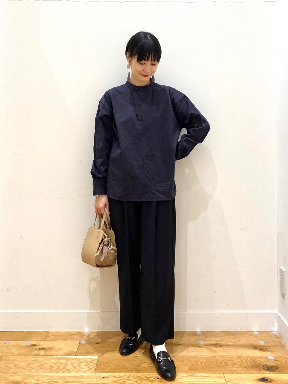 ベージュ系のダウンジャケット/コート、グレー系のシャツ/ブラウス、ブラック系のその他パンツを着用したレディースの春コーディネートの3枚目の写真