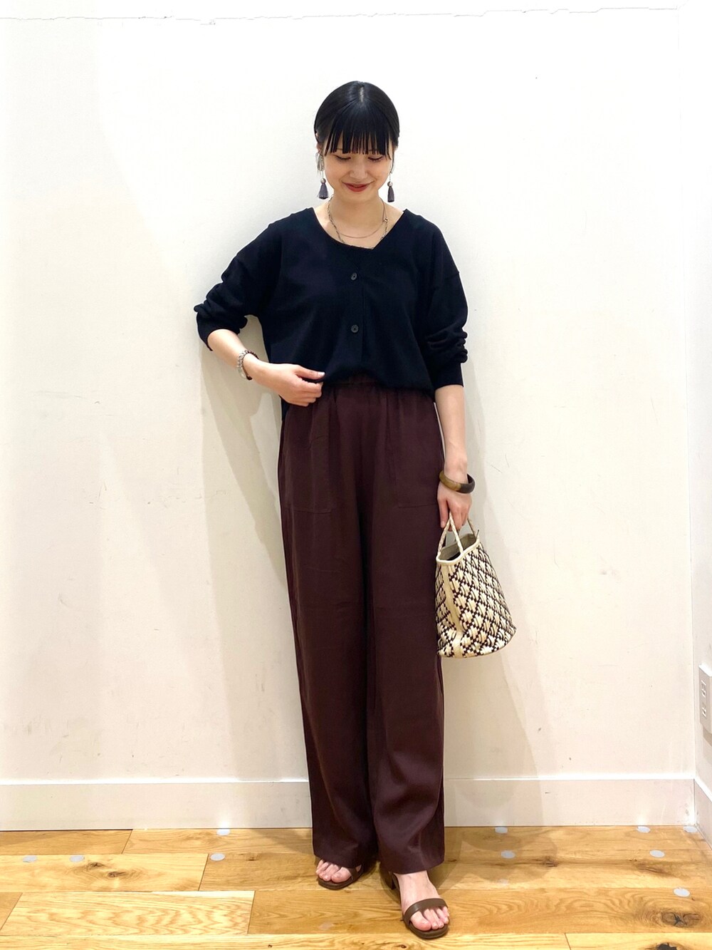 ブラック系のカーディガン/ボレロ、レッド系のその他パンツ、ブラウン系のサンダルを着用したレディースの春コーディネートの2枚目の写真