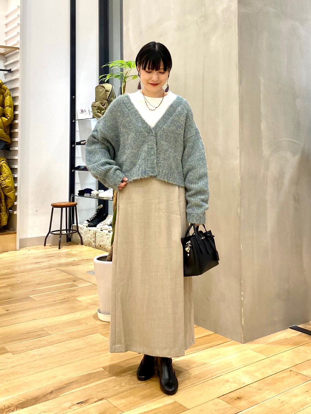 ブルー系のカーディガン/ボレロ、ホワイト系のTシャツ/カットソー、ベージュ系のスカートを着用したレディースの秋コーディネートの2枚目の写真