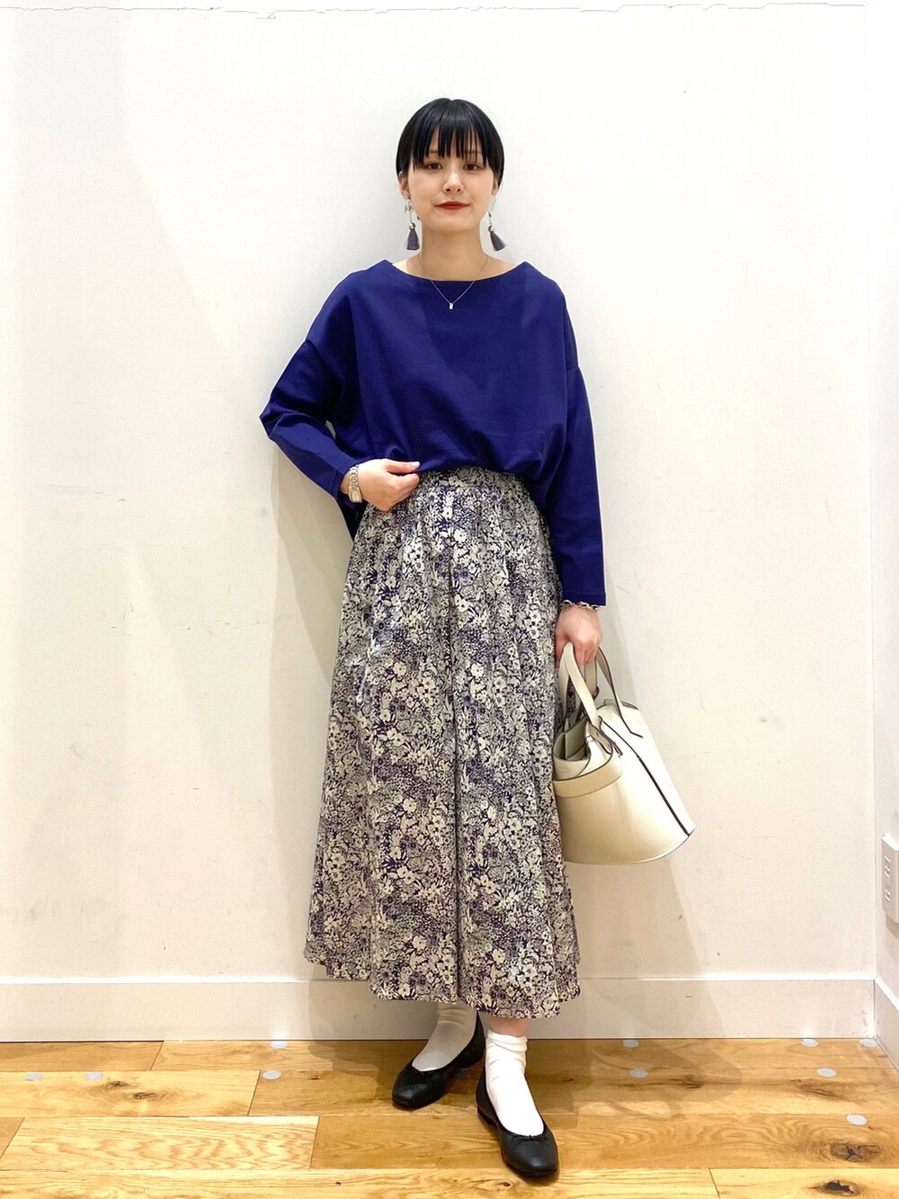 ブルー系のTシャツ/カットソー、ブルー系のスカート、ホワイト系のショルダーバッグを着用したレディースの春コーディネートの3枚目の写真