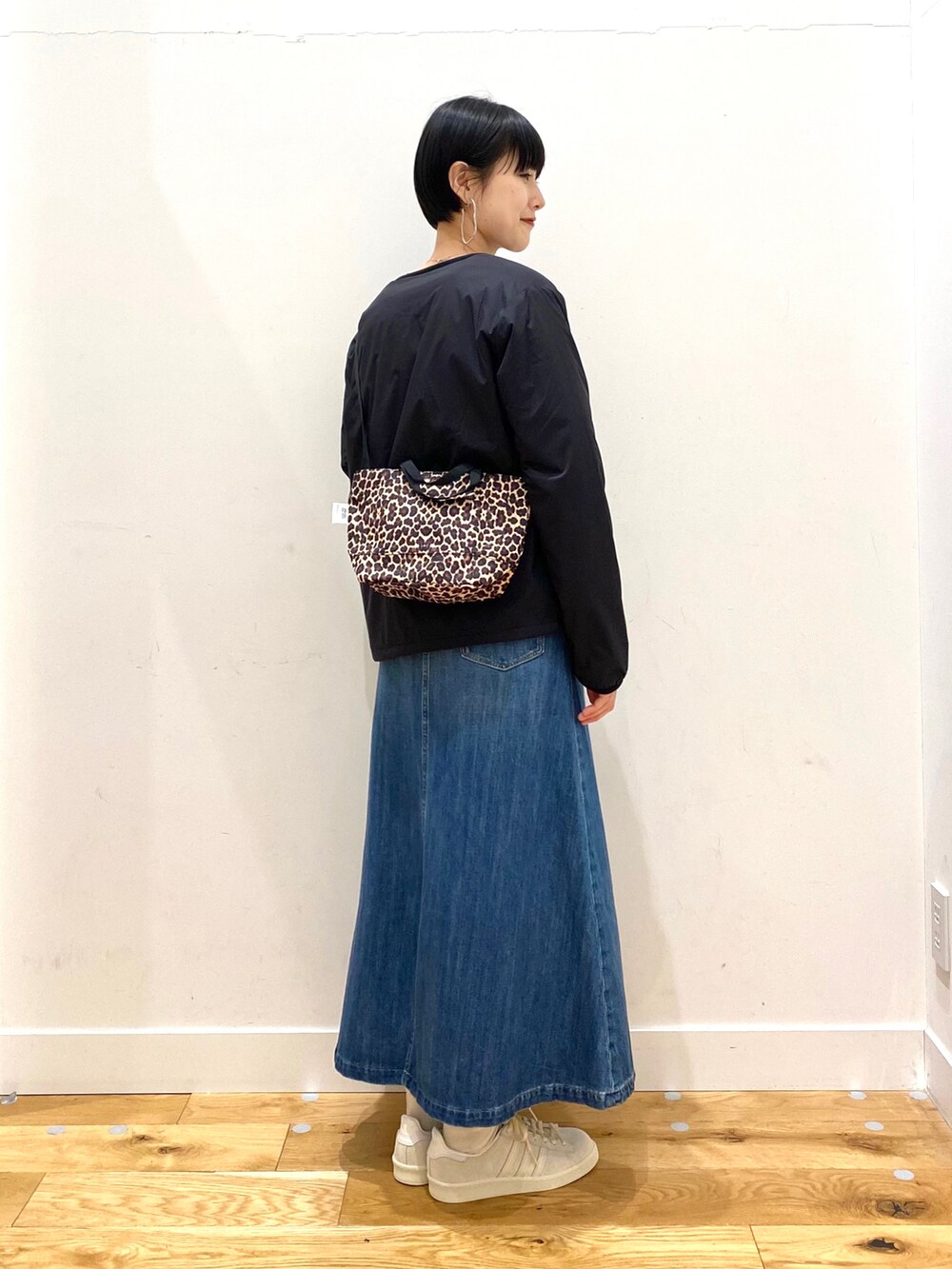 ブラック系のダウンジャケット/コート、パープル系のニット/セーター、その他のショルダーバッグを着用したレディースの春コーディネートの2枚目の写真