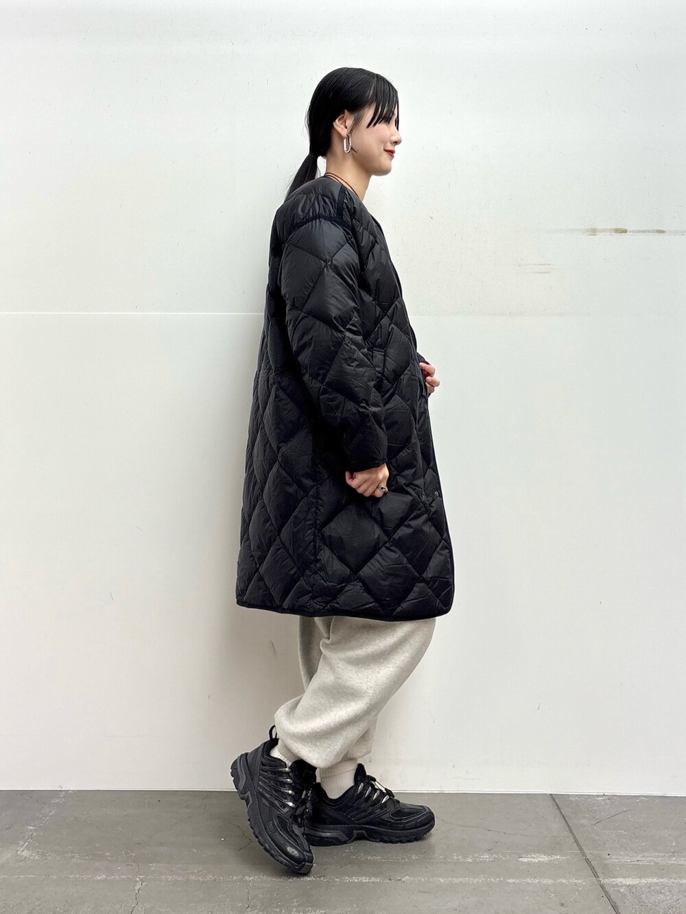 ブラック系のダウンジャケット/コート、ブルー系のニット/セーター、ベージュ系のニット/セーターを着用したレディースの冬コーディネートの2枚目の写真