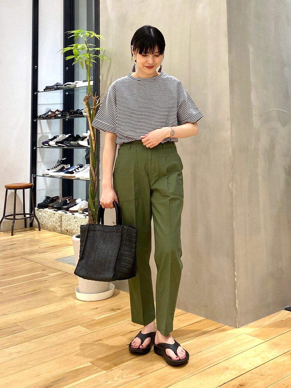 ホワイト系のTシャツ/カットソー、グリーン系のその他パンツ、ブラック系のトートバッグを着用したレディースの春コーディネートの2枚目の写真